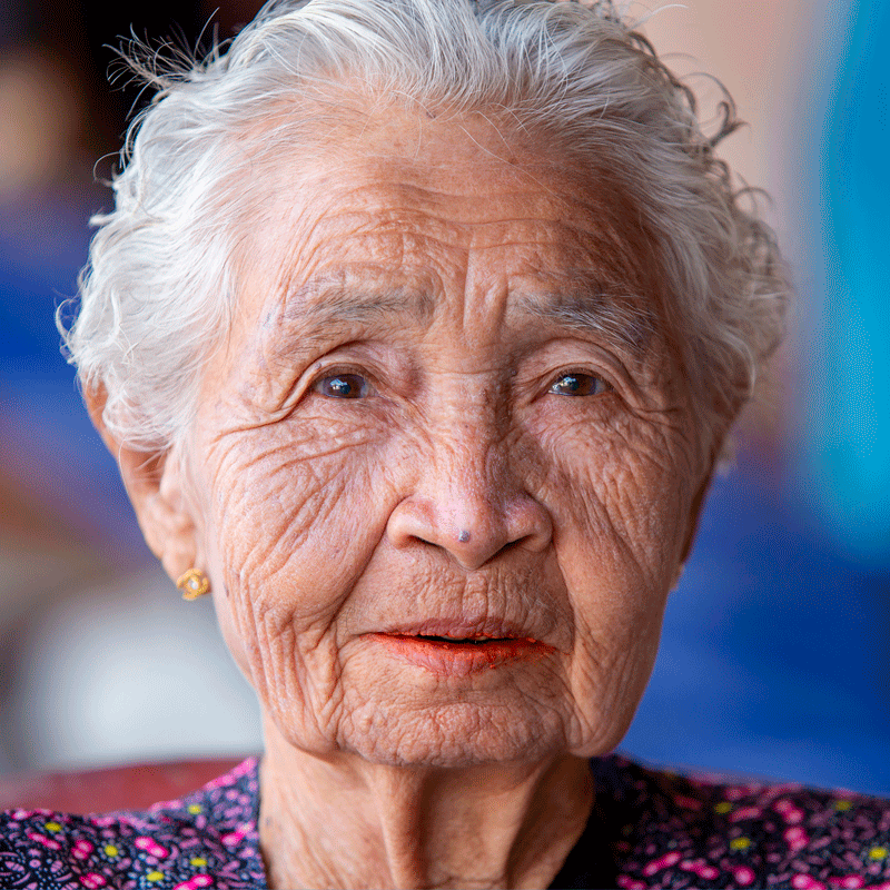 Older Asian woman looking at the camera