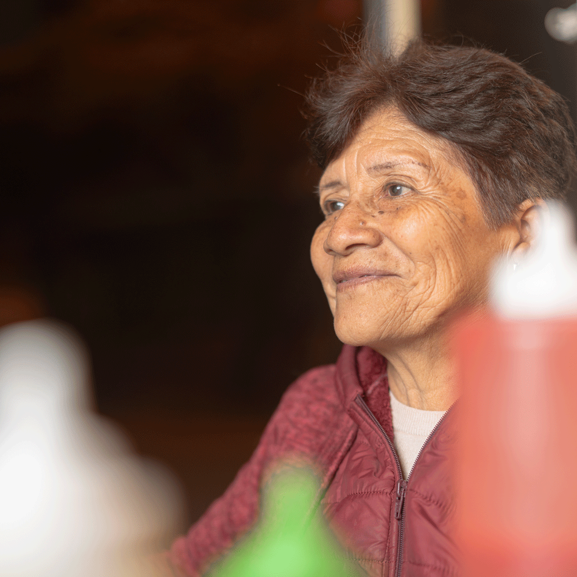 Smiling woman in a group dining environment.